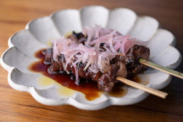 Skewers of teriyaki-glazed wagyu rump cap are topped with pickled shallots.
