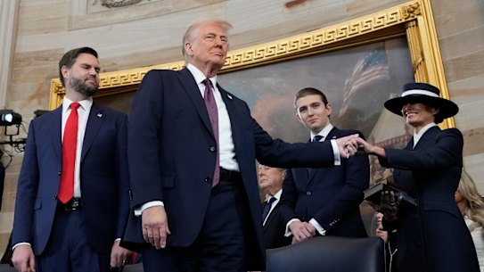 President Donald Trump, center, holds the hand of his wife Melania Trump, right, as their son Barron Trump, center, and Vice President JD Vance, look on after taking the oath of office during the 60th Presidential Inauguration in the Rotunda of the U.S. Capitol in Washington, Monday, Jan. 20, 2025. (AP Photo/Morry Gash, Pool)
