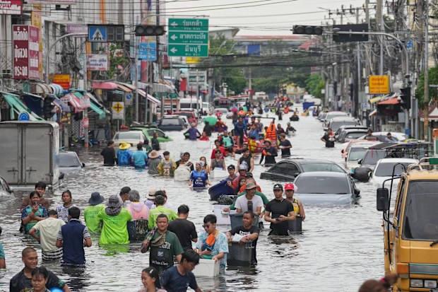People wade through a flooded street after heavy rain in Bangkok, Thailand, Monday, Sept. 28, 2026.