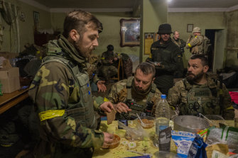Ukrayna Ulusal Muhafız askerleri, Ukrayna'nın doğusundaki Kharkiv'in eteklerinde yakın zamanda geri alınan bir köyde geçici üs olarak kullanılan bir evde toplanıyor.
