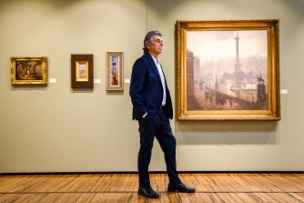Chris Deutscher of Deutscher and Hackett with Tom Roberts’ painting  A Modern Andromeda, 1892 (immediate left) and Arthur Streeton’s The Centre of the Empire, 1902 (right).