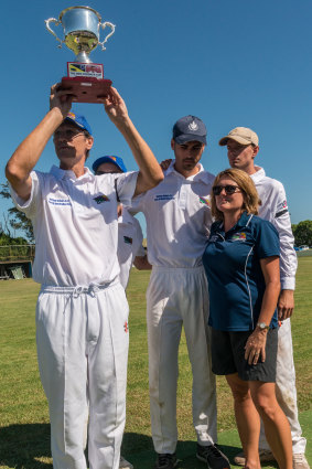 Geoff Cordner holds the Ben Cordner Cup, with his son Tim, wife Linda, and team members.