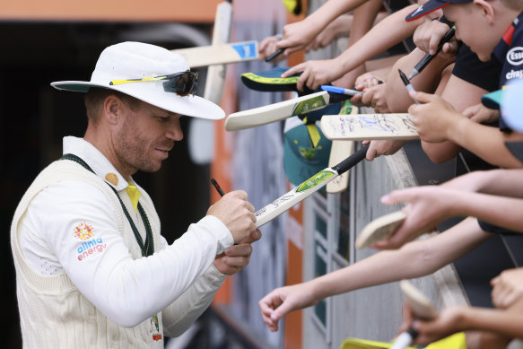 David Warner signs autographs for fans in Adelaide.