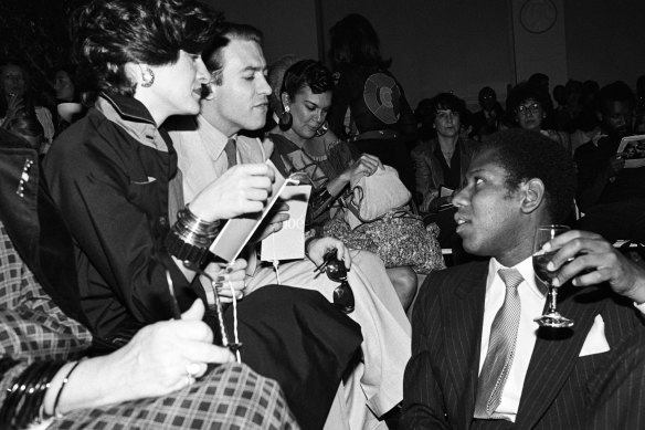 Paloma Picasso and Rafael Lopez-Sanchez talk to Andre Leon Talley in the front row during a benefit runway show of Chloe by Karl Lagerfeld for the Memorial Sloan-Kettering Cancer Center, held at Christies.