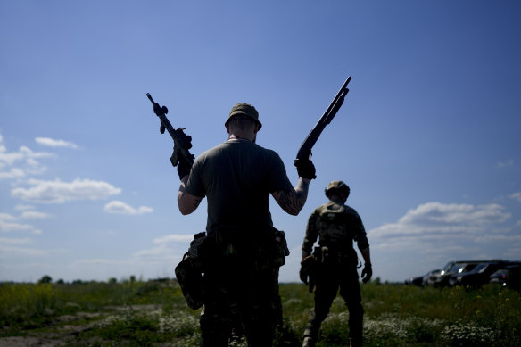 A civilian militia man holds a shotgun and a rifle during training at a shooting range in outskirts Kyiv, Ukraine.