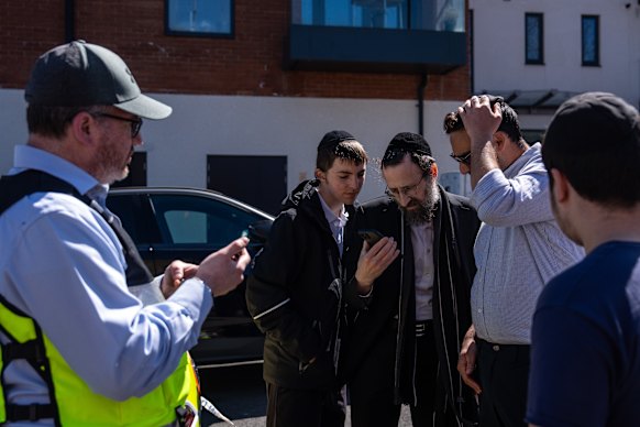 People watch a social media video of the knife attack.