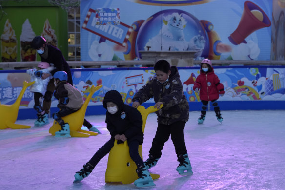 Children play at a mall where shops are reopening as restrictions ease in Beijing.