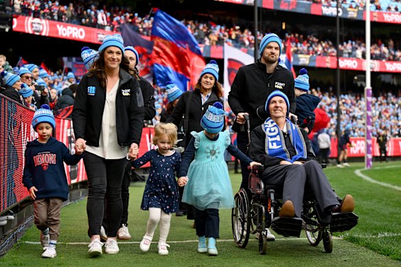 Neale Daniher and his family complete a  lap of honour at Monday’s Big Freeze game between Melbourne and Collingwood.