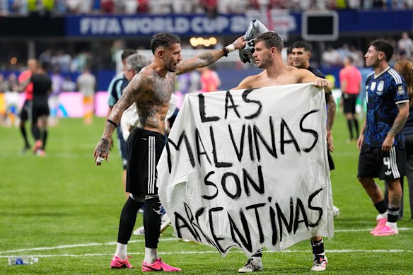 Argentina’s Giovani Lo Celso holds a banner with the words “The Malvinas are Argentine”, referring to the Falkland Islands, while teammate Argentina’s Nicolas Otamendi gestures to him.