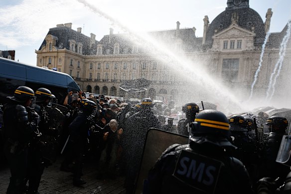 Riot police use a water cannon on students in Rennes.