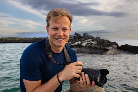 Bertie Gregory photographing Galapagos penguins with marine iguanas.  