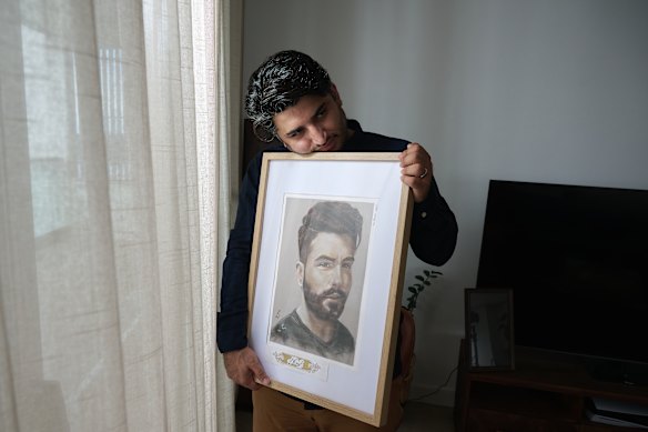 Mohammad Hashemi at his Sydney home with a picture of his cousin who died at the hands of the Iranian regime following protests two years ago.