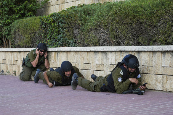 Israeli soldiers take cover as a siren sounds a warning of incoming rockets fired from the Gaza strip.