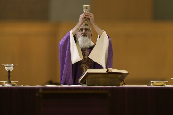 Revened Gabriel Landis prepares Communion during a Catholic Mass at Benedictine College in Atchison, Kansas.