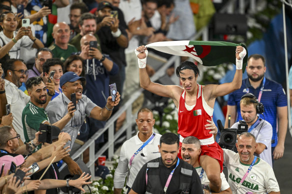 Imane Khelif is carried out of the ring by her coaching staff after winning the gold medal fight.