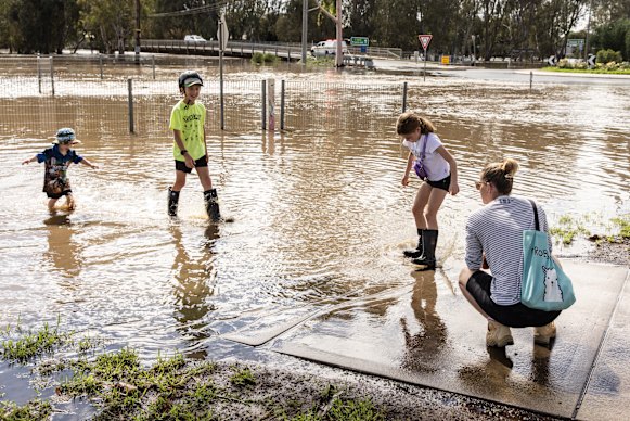 Children wade through floodwater in Rochester on Tuesday.