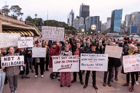 Protesters opposed to the Everest barrier draw being projected onto the Sydney Opera House display placards while at a forecourt rally.