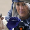 A nurse takes a swab from a patient at a drive-through coronavirus testing site in Salt Lake City.