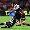 Filipo Daugunu of the Reds is tackled by Callum Harkin of the Hurricanes.