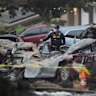 Vehicles are damaged as authorities work the scene of the plane crash.