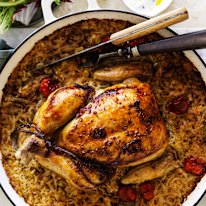 Roast chicken on baked rice with tomato, cumin and bay leaves.