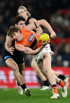 Outta my way: Tom Green looks to dish a handball against the Blues.