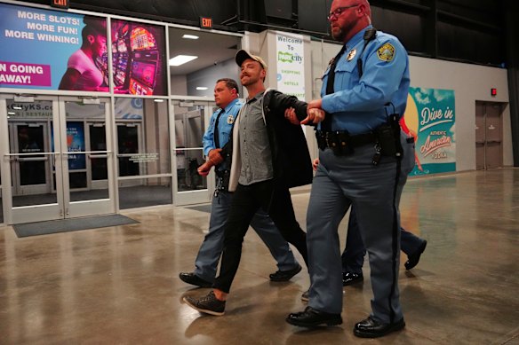 Police remove a protester from the arena in Park City, Kansas. There were at least six hecklers who disrupted the rally.