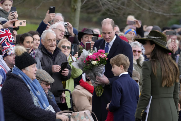 William and Catherine, Prince and Princess of Wales, greet royal fans with their son Prince George on Christmas day.
