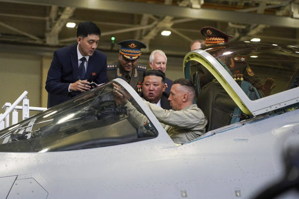 North Korean leader Kim Jong-un (centre) looks at a military jet cockpit while visiting a Russian aircraft plant that builds fighter jets.
