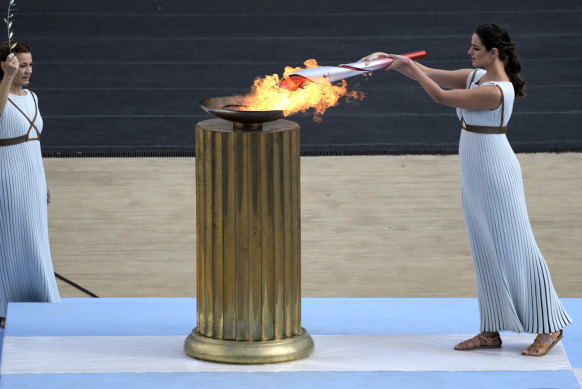 Greek actress Xanthi Georgiou lights the torch with the flame during the Olympic flame handover ceremony at Panathinean stadium in Athens, Greece in 2021. In 2024 the Olympic flame will travel by sea to France. 