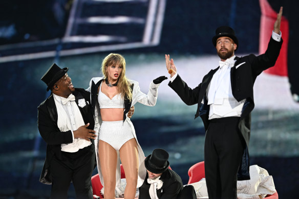 NFL star Travis Kelce (right) dons a top hat and tails to join girlfriend Taylor Swift on stage in London. 