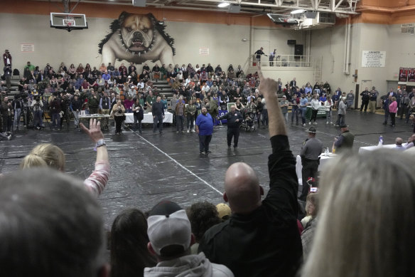 A man raises his hand with a question for East Palestine, Ohio Mayor Trent Conaway, centre, during a town hall meeting at East Palestine High School on Wednesday.