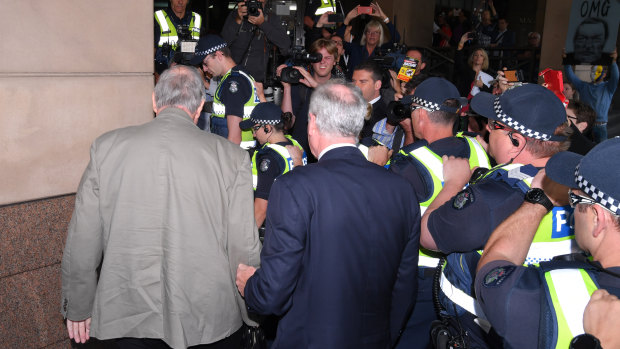 Cardinal George Pell braves the throng outside the Melbourne Magistrates Court on Monday. 