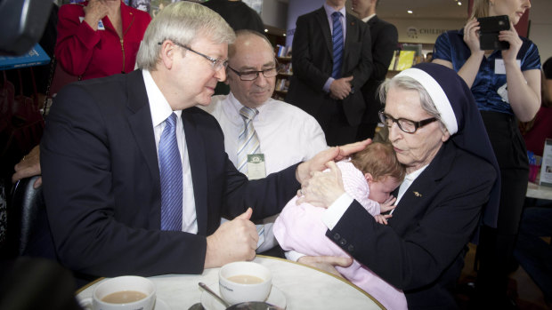 Then-Prime Minister Kevin Rudd meets six-week-old Evie Brough and Sister Angela in Brisbane during 2013.