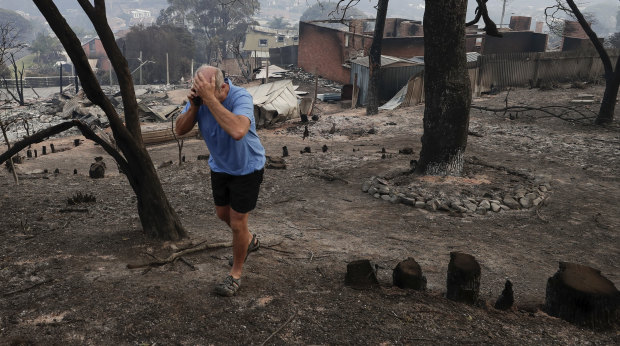 Tathra resident John Plumb on the mobile phone after viewing the aftermath of the Tathra bushfire.