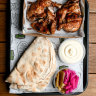 Whole chicken plate with pickles, pita and toum at El Jannah in Preston.