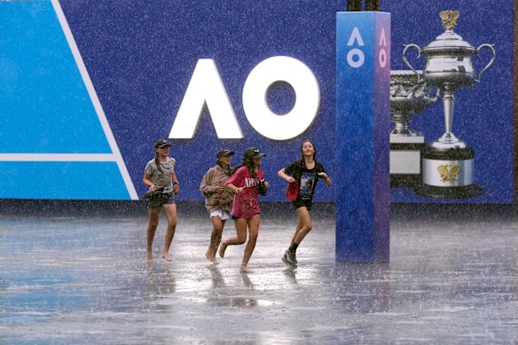 Children run as rain suspends play in the first-round matches.
