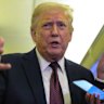US President Donald Trump speaks to reporters aboard Air Force One.