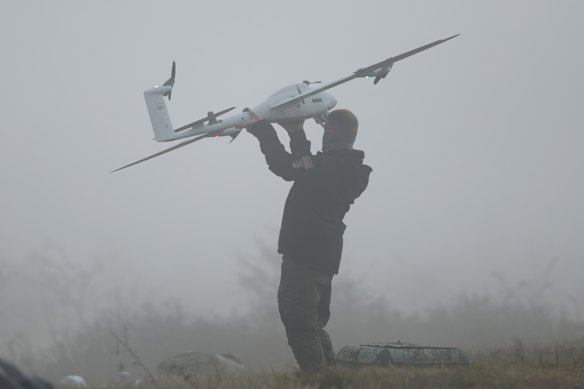 A technician of German drones maker Quantum Systems retrieves a Vector AI fixed wing reconnaissance drone in fog during a multi-domain operations exercise of Quantum Systems on October 20, 2026 at an undisclosed training area in central Germany.