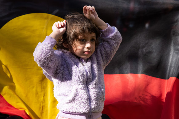 A young girl puts her fists up in the air in a sign of protest during a rally against Rio Tinto's decision to blast sacred Aboriginal sites in the Pilbara earlier this year.