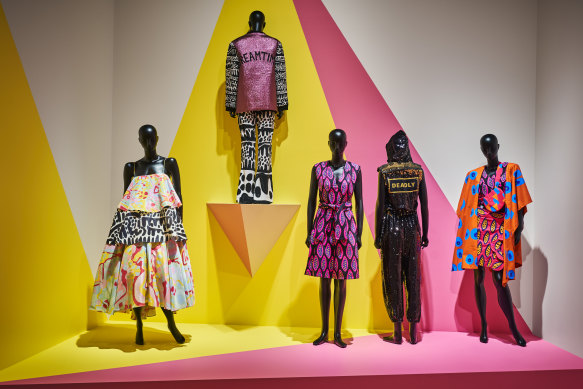 Piinpi's Blak and deadly, Urban street wear, from left: Arkie Barton's  Rainbow dreaming dress,  2015, and Dreamtime jacket and Spinifex flares, 2015; Shannon Brett's Femme gem dress, 2020; Teagan Cowlishaw's Deadly kween jumpsuit, 2019; Shannon Brett's Femme gem pants, top and bag, 2020. 


