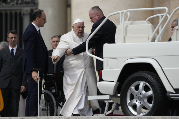 Pope Francis helped to get on his car at the end of weekly general audience in St Peter’s Square, at the Vatican.