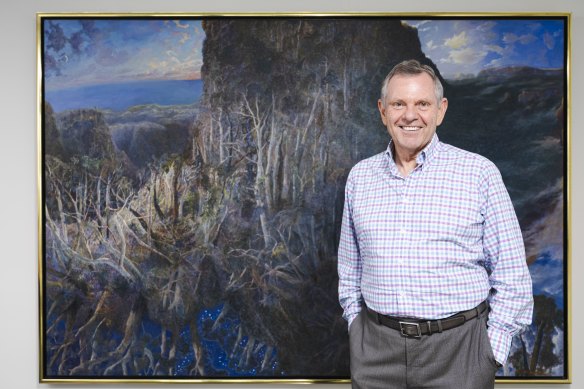 Philip Bacon with a painting from his private collection by William Robinson. “I think Robinson is certainly Queensland’s greatest artist, but he’s probably the greatest living Australian landscape painter now that John Olsen’s dead – there was always a bit of a fight between the two.”