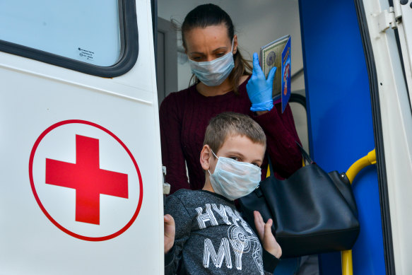 A boy and his mother leave a COVID-19 testing unit in Adygea, Russia.