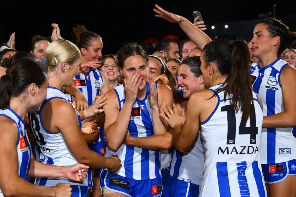 Jasmine Garner, middle, is mobbed by teammates after being announced as the best on ground in the 2024 AFLW grand final.
