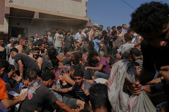Palestinians struggle to collect humanitarian aid airdropped by parachutes into Gaza City.