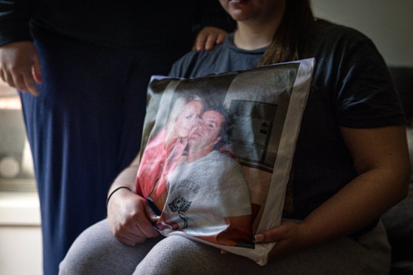 Charlie holds a cushion with a picture of her parents, Zoe and George.