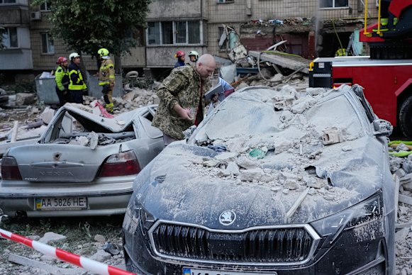 A local resident inspects a damaged car after a Russian missile attack in Kyiv on Monday.