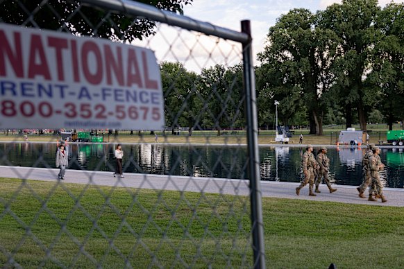 Members of the National Guard patrol near fencing around the perimeter of the Reflecting Pool. 