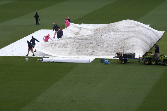 SCG grounds crew remove the covers from the wicket area after a rain delay last year.